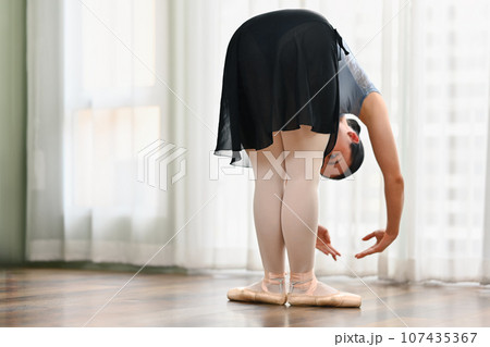 Young ballerina practice ballet near window in dance class. Dance, art, education and flexibility concept 107435367