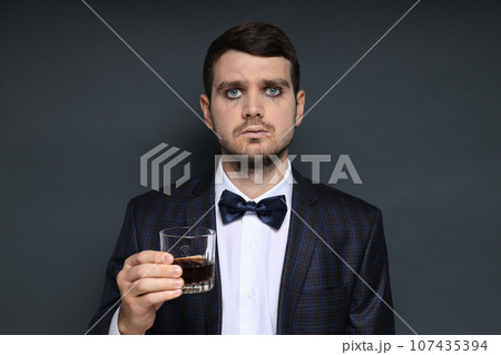 A man in a zombie costume with a drink in his hand on a black background 107435394