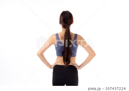 Portrait of beautiful young asian woman in sportswear showing waist and abs isolated. 107437224