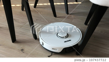 Robot vacuum cleaner with lidar navigation clean around chair. Smart cleaning technology. Robot vacuum cleaner with lidar navigation clean around chair. Smart cleaning technology. 107437722