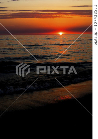 Sunset over the water on a dark background of sunlight over the Mediterranean Sea Sunset over the water on a dark background of sunlight over the Mediterranean Sea 107438551