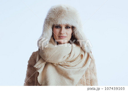 modern woman in winter coat and fur hat on white 107439103