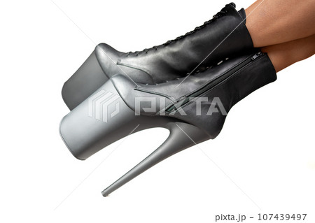 Black pole dance shoes. Woman legs in black high heels isolated on a white background. Sexy striptease dancer. Close-up view. Black pole dance shoes. Woman legs in black high heels isolated on a white background. Sexy striptease dancer. Close-up view. 107439497