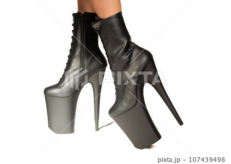 Black pole dance shoes. Woman legs in black high heels isolated on a white background. Sexy striptease dancer. Close-up view. Black pole dance shoes. Woman legs in black high heels isolated on a white background. Sexy striptease dancer. Close-up view. 107439498
