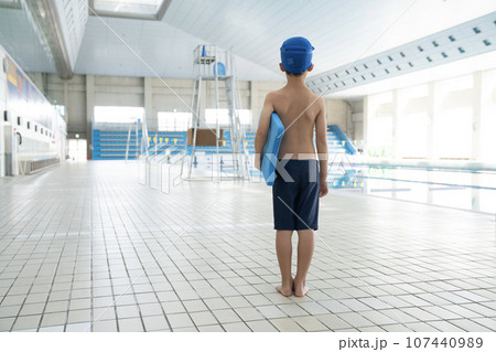 室内プールでビート板を持つ少年の後ろ姿 107440989
