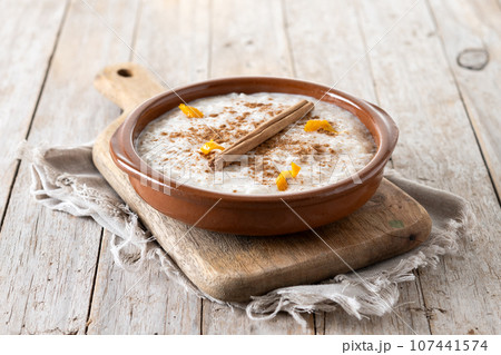 Arroz con leche. Rice pudding with cinnamon in bowl on wooden table. 107441574
