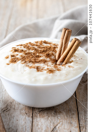 Arroz con leche. Rice pudding with cinnamon in bowl on wooden table Arroz con leche. Rice pudding with cinnamon in bowl on wooden table 107441630
