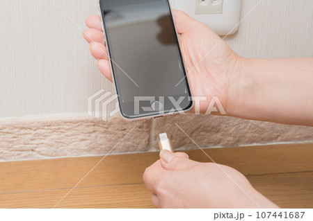 【スマホを充電する主婦】 107441687