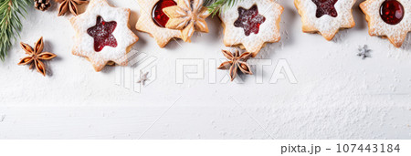 Linzer cookies with sweet jam and fir tree branches on wooden table. Top view Linzer cookies with sweet jam and fir tree branches on wooden table. Top view 107443184