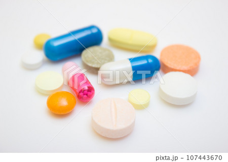 Many tablets and capsules, white background - protection quarantine, coronavirus, covid19 107443670
