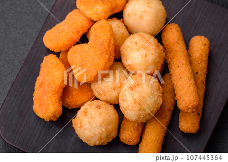 Delicious nuggets, sticks and balls of mozzarella and parmesan cheese with salt and spices 107445364