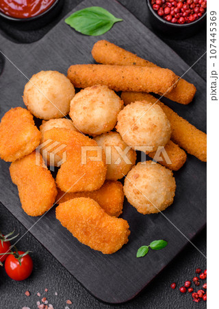 Delicious nuggets, sticks and balls of mozzarella and parmesan cheese with salt and spices Delicious nuggets, sticks and balls of mozzarella and parmesan cheese with salt and spices 107445369