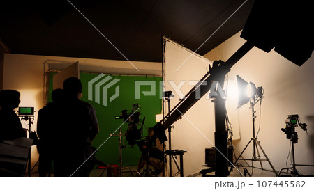 Silhouette images of making of or behind the scenes of video production which produced in the film studio that include all pro light and camera equipment and professional film crew with movie director Silhouette images of making of or behind the scenes of video production which produced in the film studio that include all pro light and camera equipment and professional film crew with movie director 107445582