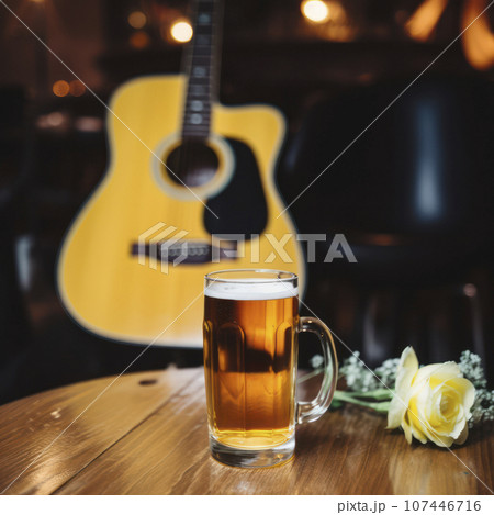 glass of beer next to guitar on a table glass of beer next to guitar on a table 107446716