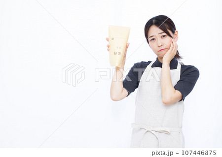 白い背景の前で給料袋を持ち悩んでいる30代の主婦 107446875