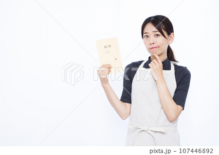 白い背景の前で給料袋を持ち悩んでいる30代の主婦 107446892
