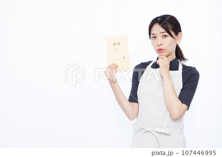 白い背景の前で給料袋を持ち悩んでいる30代の主婦 107446995