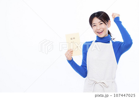 白い背景の前で給料袋を持ちガッツポーズをしている30代の主婦 107447025