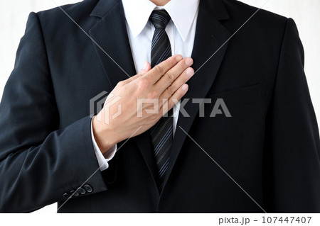 胸に手をあてるビジネスマン 107447407