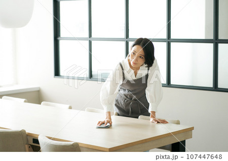 テーブルの上を拭く女性の写真 107447648