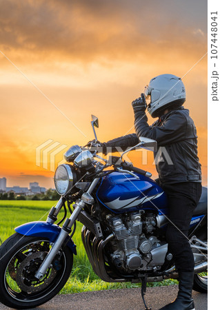 夕焼空と男性ライダー 107448041