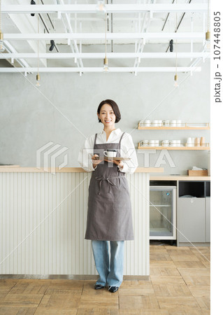 コーヒーを持つカフェ店員 107448805