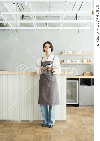 コーヒーを持つカフェ店員 107448806