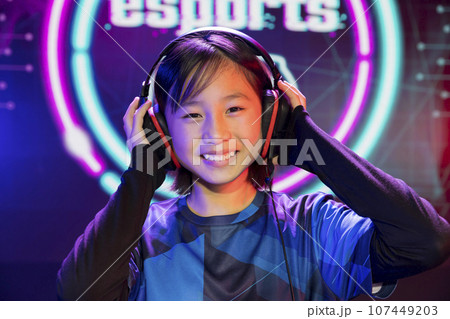 eスポーツイメージ ゲーミングヘッドホンを装着する笑顔の女の子 eスポーツイメージ ゲーミングヘッドホンを装着する笑顔の女の子 107449203