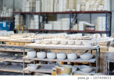 Abundance of crafted ceramic bowls in pottery workshop 107449653