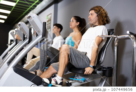 Motivated man doing cardio workout on exercise bike in gym 107449656