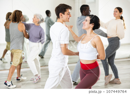 Young Hispanic woman and guy enjoying active dancing in pair 107449764