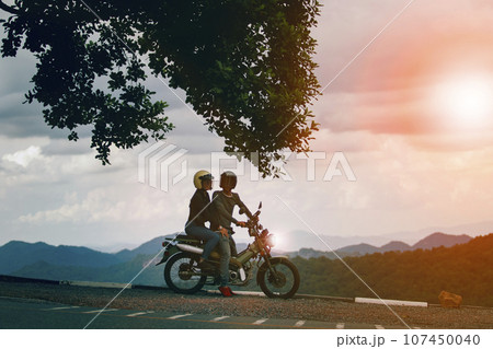 couples wearing safety helmet sitting on small enduro motorcycle against beautiful natural mountain scene at khaoyai national park thailand couples wearing safety helmet sitting on small enduro motorcycle against beautiful natural mountain scene at khaoyai national park thailand 107450040
