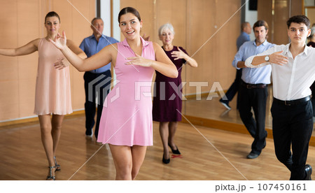 Couple of young dancers rehearsing ballroom dances in dance studio Couple of young dancers rehearsing ballroom dances in dance studio 107450161