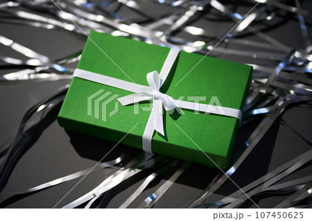 Green box with gifts on a gray background. Green box with gifts on a gray background. 107450625