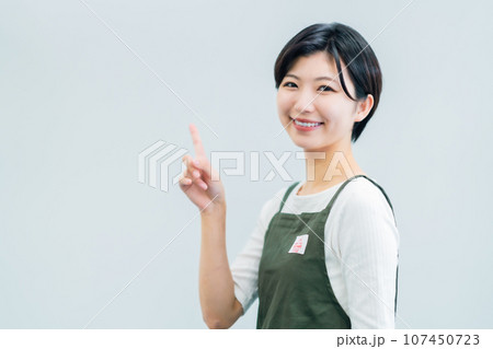 指差しポーズの飲食店で働く若い女性 白バック 指差しポーズの飲食店で働く若い女性 白バック 107450723