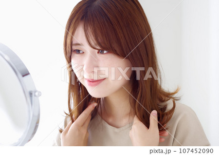綺麗な髪の毛を撫でる若い女性 107452090