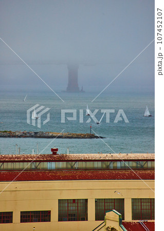 Warehouse with boats on San Francisco Bay with foggy and obscured Golden Gate Bridge Warehouse with boats on San Francisco Bay with foggy and obscured Golden Gate Bridge 107452107