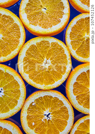 Close up of orange slices on navy blue background Close up of orange slices on navy blue background 107452126