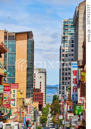 Chinatown in San Francisco with shop and restaurants signs along road leading to the bay 107452337