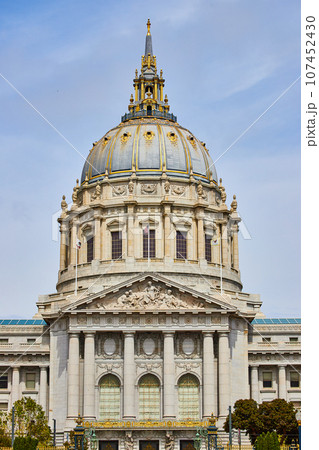 Close up of city hall entrance with focus on gilded dome and white pillars above doors Close up of city hall entrance with focus on gilded dome and white pillars above doors 107452430