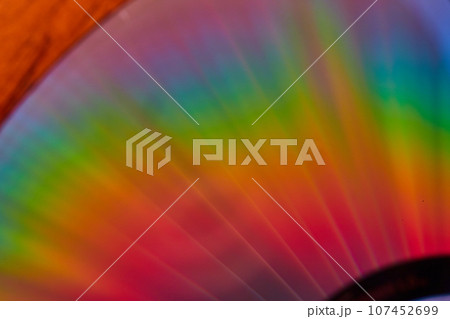 Brilliant rainbow streams of light close up of CD surface in abstract shot 107452699