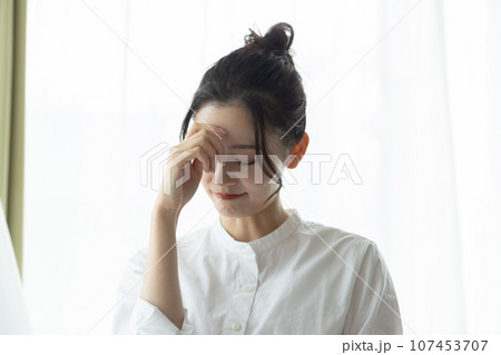 頭痛がする女性 107453707