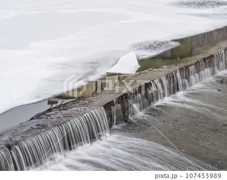 A small flat cascade in a calm river 107453989