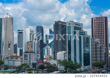Kuala Lumpur, Malaysia - 26 August 2023: Malaysian buildings and big scyscrappers against blue sky Kuala Lumpur, Malaysia - 26 August 2023: Malaysian buildings and big scyscrappers against blue sky 107454454