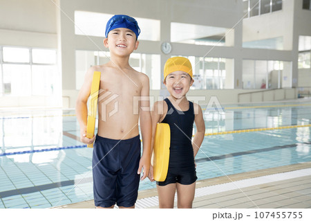 室内プールでビート板を持って笑う兄弟 107455755