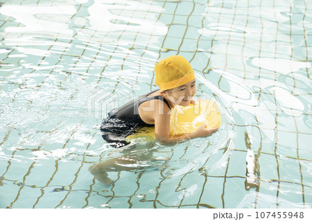 プールでビート板を持って泳ぐ少女 プールでビート板を持って泳ぐ少女 107455948