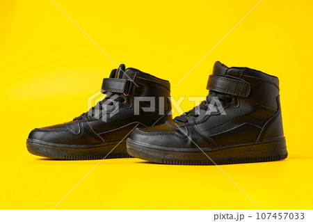 Black new sport sneakers on yellow background Black new sport sneakers on yellow background 107457033
