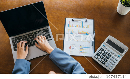 Businesswoman checking and analysing report, Accountant calculate financial report, top view business woman working on laptop computer with chart graphs and calculator, finance analysis concept Businesswoman checking and analysing report, Accountant calculate financial report, top view business woman working on laptop computer with chart graphs and calculator, finance analysis concept 107457114