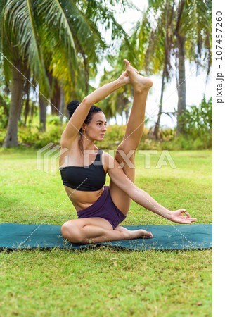 Compass pose or Surya Yantrasana yoga with ukrainian woman making it outdoors Compass pose or Surya Yantrasana yoga with ukrainian woman making it outdoors 107457260