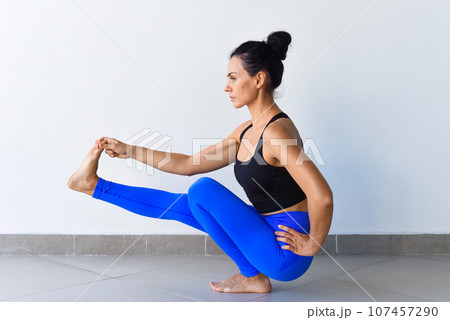hand to big toe pose squat variation utthita hasta padangusthasana yoga with ukrainian woman making it indoors 107457290